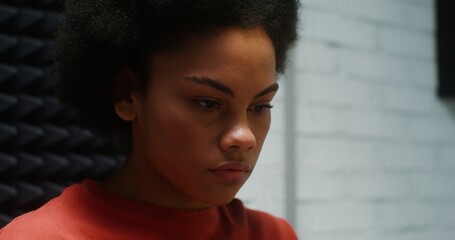 Close-up face of a beautiful young woman of African American appearance with a lush hairstyle,...