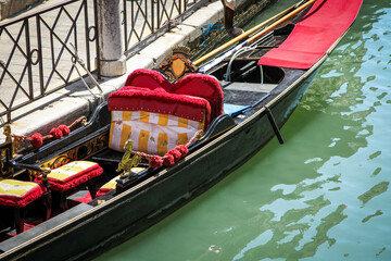 A black gandola in the city of venice in Italy with a red seat and a white seat © vip-photoworld