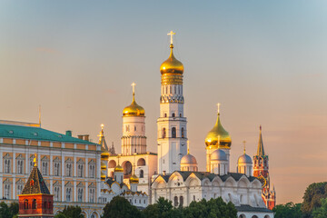 Ivan the Great Bell Tower, with Assumption Belfry on the right in Moscow Kremlin. Blue sky background with sunbeams