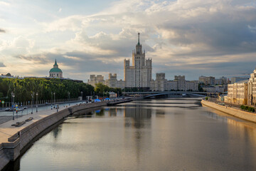 Naklejka premium Moscow embankment at sunrise with the river reflecting the morning glow, showcasing peaceful streets, grand Stalinist architecture, and the quiet charm of the city before the day begins