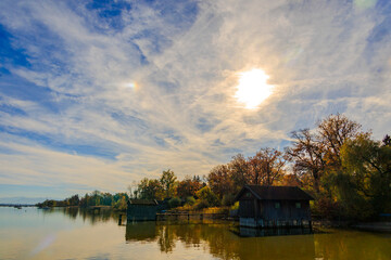 Obraz premium Rustic boathouse on stilts over calm lake, Ammersee, Germany, Riederau, 01.11.2024..