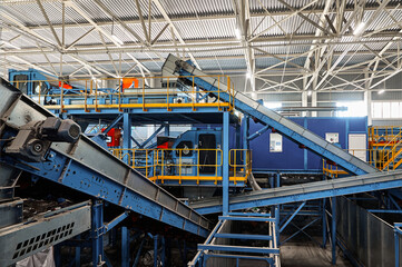 Conveyors carry trash and empty platforms at recycling plant