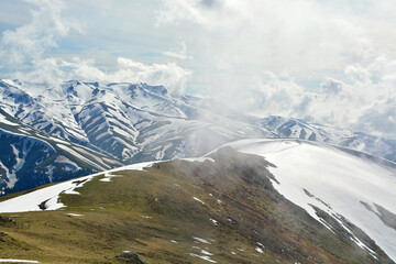mountain landscape with snow and clouds