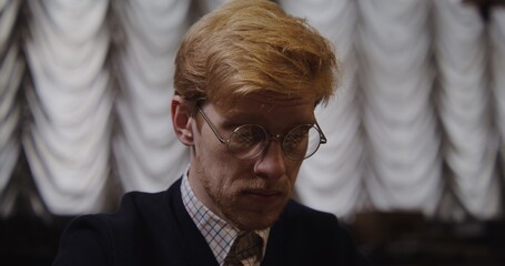 A European-looking man wearing a business suit thinks intently while looking at the chessboard before making a move, close-up