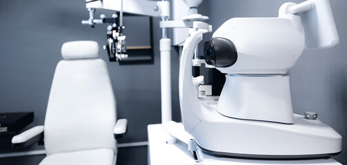 Modern optometry equipment in eye examination room, banner