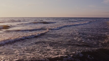 Fototapeta premium Large foamy waves at high tide, drone video. Sea waves from a bird's eye view.