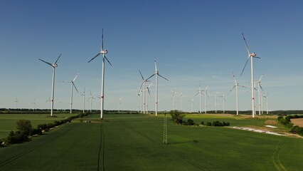 Large wind farm, extracting electricity from the wind. Drone video on a sunny day. Wind turbines in...