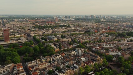 Top view of the Amsterdam canal between the streets with beautiful old traditional houses. Ships moored along the embankment, drone video. Amsterdam, Netherlands