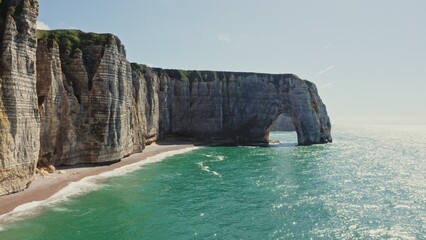 Alabaster sheer cliffs with a picturesque natural arch, washed by the waters of the English...