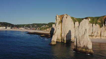 The European city of Etretat, located in a picturesque place between sheer limestone cliffs on the English Channel Bank, France, video from the sea from a drone