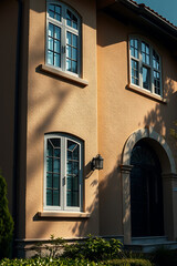 Fototapeta premium Elegant Home Exterior: Architectural Design and Sunlight Shadows on Facade. Classic Style Residential Building, Real Estate Property
