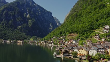 Naklejka premium A small Austrian town located on the coast of a picturesque lake at the foot of green mountains. Austria, Hallstatt, drone video