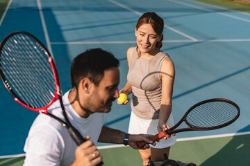 Young couple playing tennis outdoors enjoying a fun summer game