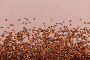 Brown linen seeds on beige background. Flaxseed background. Healthy super food top view, flat lay...