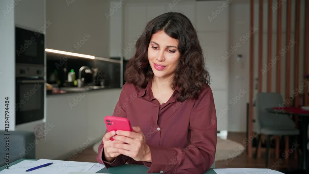 Canvas Prints Focused young middle easter or latin hispanic woman using online smartphone app remote work chatting, sitting at desk in workplace at home office. Smiling businesswoman working at mobile phone device