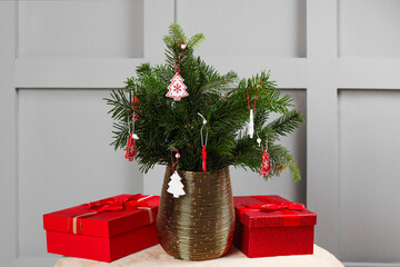 Beautiful decorated fir tree branches and Christmas gifts on pouf indoors