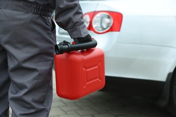 Man with canister near car outdoors, closeup