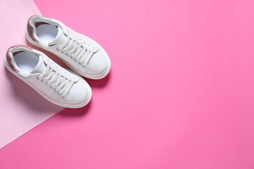 Sportive shoes. Pair of stylish sneakers on pink background, flat lay. Space for text