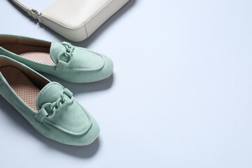 Pair of stylish shoes and bag on white background, above view. Space for text