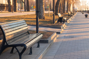 Wooden antique bench in the promenade area on the city embankment