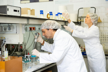 Man and woman scientists chemists conduct various experiments in a research laboratory