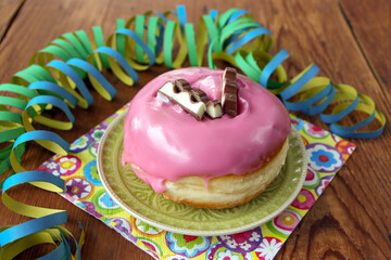 krapfen mit rosa zuckerguss und schokoriegel topping