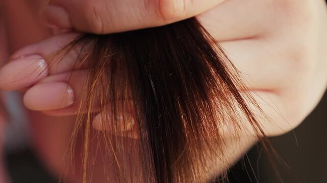 Unhealthy brown hair. Woman touching her damaged split hair. High quality 4k footage
