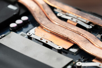 Detailed view of copper heat pipes connecting various components on a circuit board, highlighting...