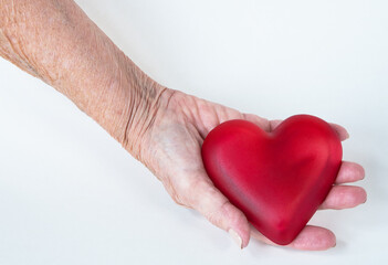 Obraz premium Elderly Right Hand Holding Red Glass Heart