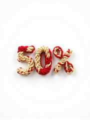 The number percent knitted with knitting needles from soft and delicate soft fabric in mix of a red beige color, on a white background. Soft, puffy, and with visible fibers, as if it were hand-spun