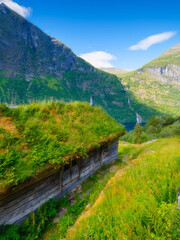 Geiranger Fjord, Norway. Nature in fjords. Traveling on a Norwegian fjord. Scandinavia. Traditional old settlement. Houses with moss on the roof.