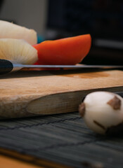 Tomatoes, peppers and onions on a cutting board on a dark background, Preparation of a vegetable salad with fresh tomatoes, pepper, garlic and onions. Chopped garlic on a wooden cutting board and fres