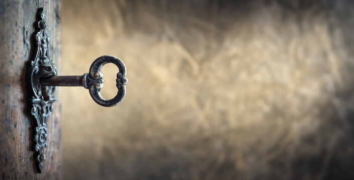 Old key in keyhole, macro shot. Gothic style. Key to knowledge. Concept and Idea for History, education, security, imprisonment, dungeon, prison background.