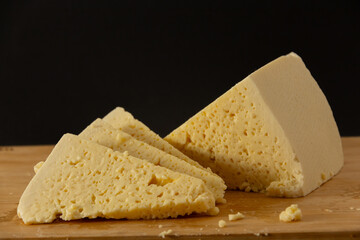 cheese guda on wooden desk, sliced, Georgian traditional food