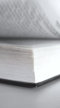 Flip through the pages of a book. Flipping book pages, reading and education. Flicking Through Old book Close-up, macro shot of paper, Vertical video
