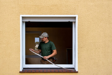 Carpenter Installing an Energy-Efficient Window in a House Renovation.
