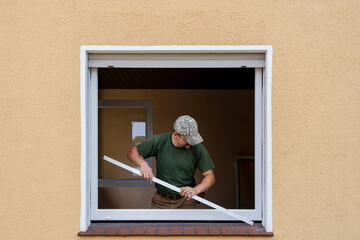 Carpenter Installing an Energy-Efficient Window in a House Renovation.