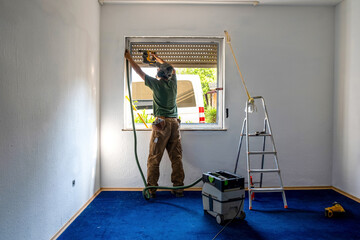 Carpenter Installing an Energy-Efficient Window in a House Renovation.