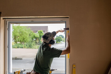 Carpenter Installing an Energy-Efficient Window in a House Renovation.