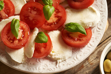 Fresh tomatoes, mozzarella cheese and basil in an Italian Caprese salad, closeup