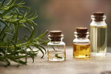 Bottles of aromatherapy essential oil with fresh rosemary twigs