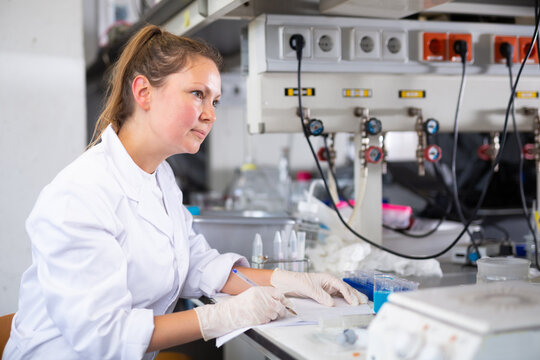 Woman technical expert making notes in lab. High quality photo