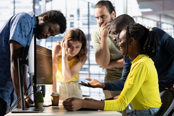 IT staff members discussing and working, testing and deploying programs and systems. Team of...