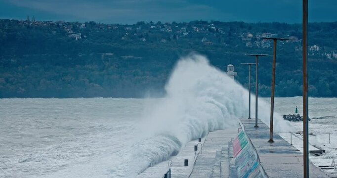 Storm at sea with big waves crashing on the beach shore and coastal harbor lighthouse port Varna, Bulgaria