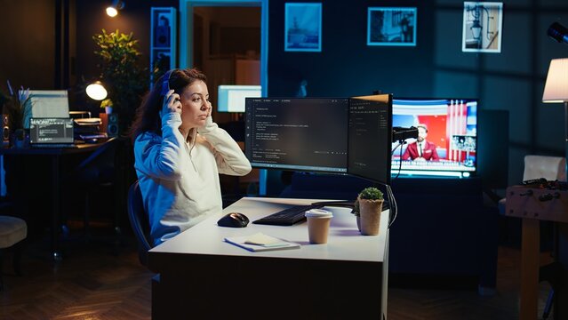 Freelancing programmer listening music while designing and developing software applications. IT specialist wearing headphones, implementing and maintaining company systems, camera B