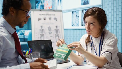 Physician recommending vitamins and painkillers on healthcare insurance, writing a stamped...