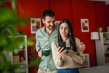 relax couple drink coffee and use mobile phone together at home