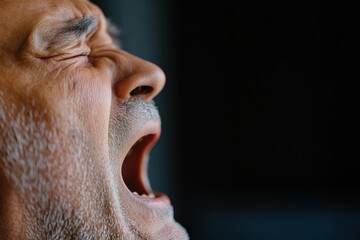 This powerful image presents an elderly man expressing his emotions through a yawn, exuding raw energy and deeper reflections on life amidst contrasts of shadow and light.