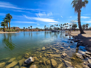 A gorgeous landscape at Papago Park with a lake, lush green palm trees and rocks in Phoenix Arizona USA