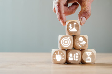 Wooden blocks with challenge icons representing goals, success, and teamwork. Perfect for business...